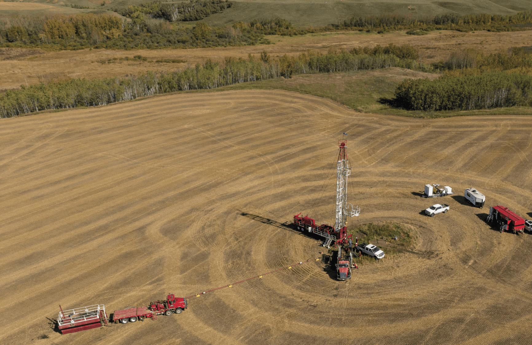 Crbon Labs well-plugging site — golden field with active drilling rig